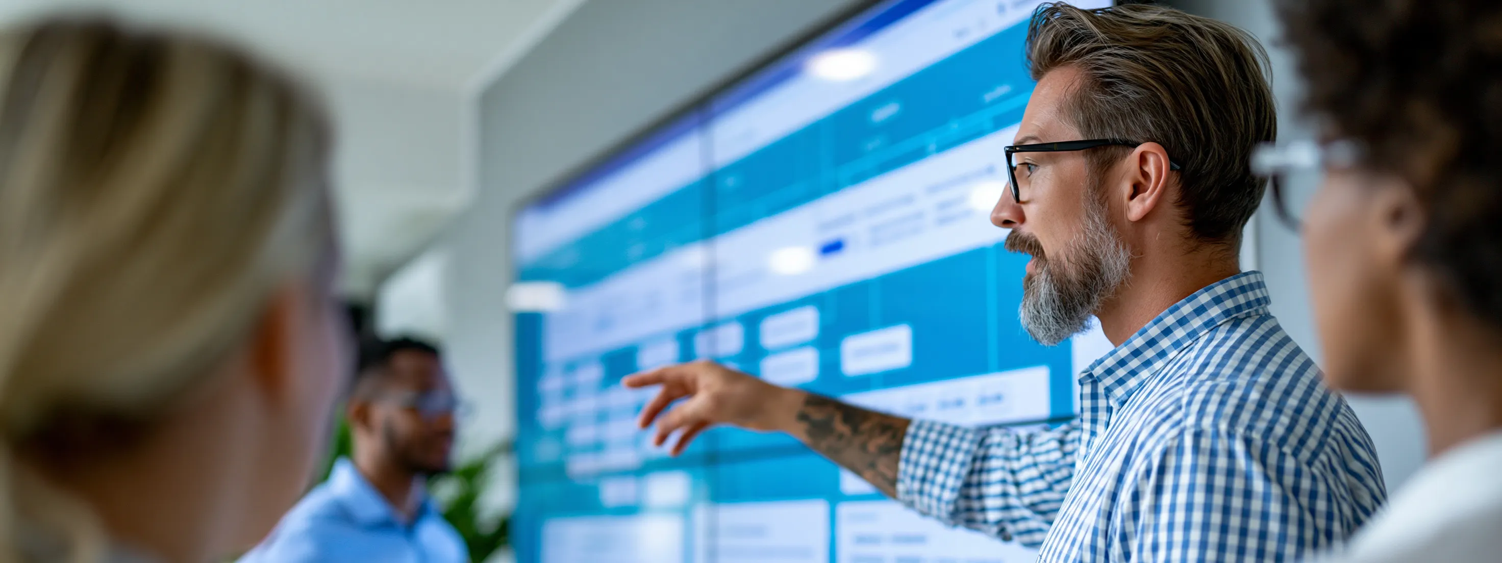 A team working through a plan on a large wall display