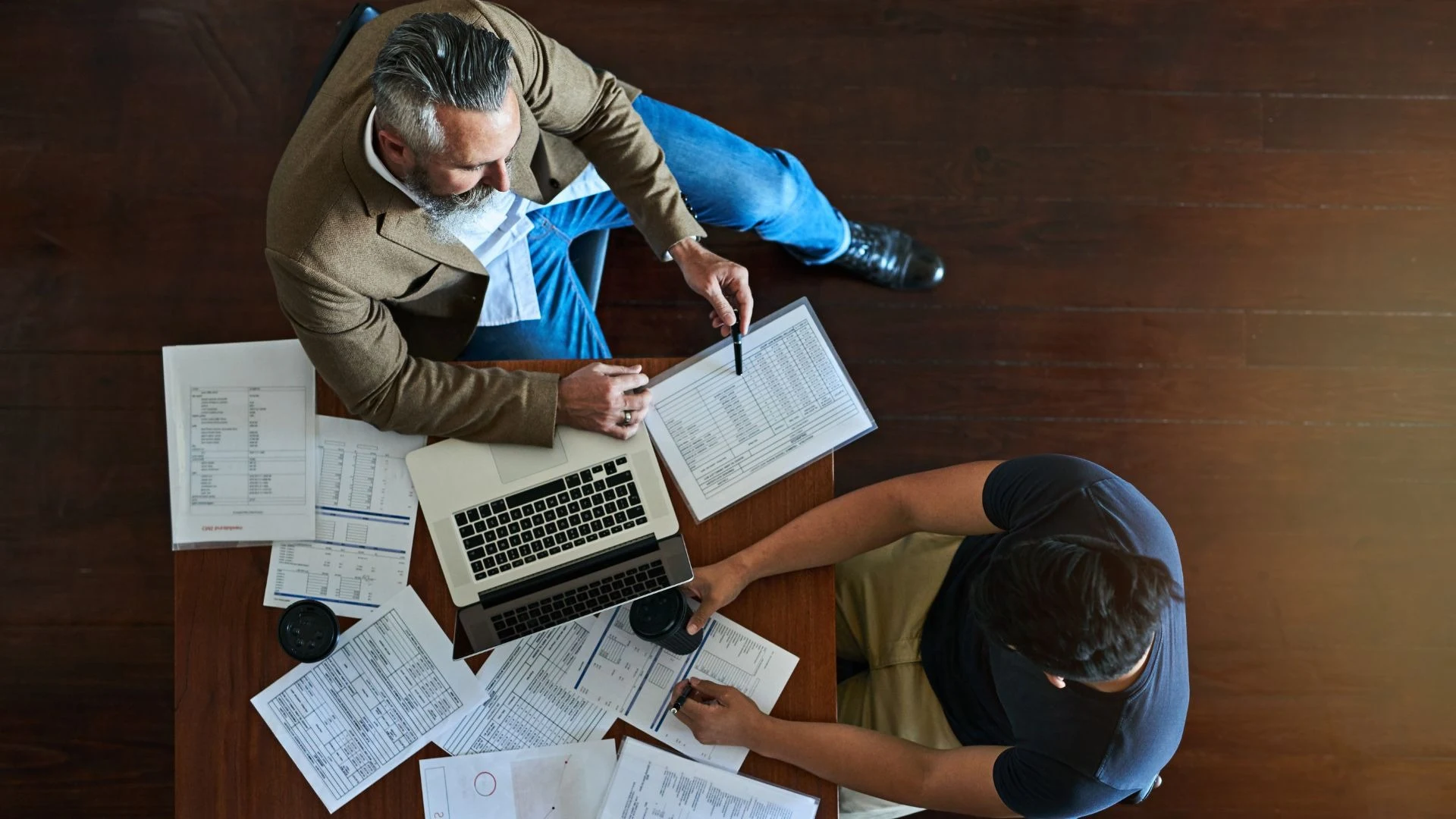 Two people reviewing hardware quotes and order paperwork across a desk