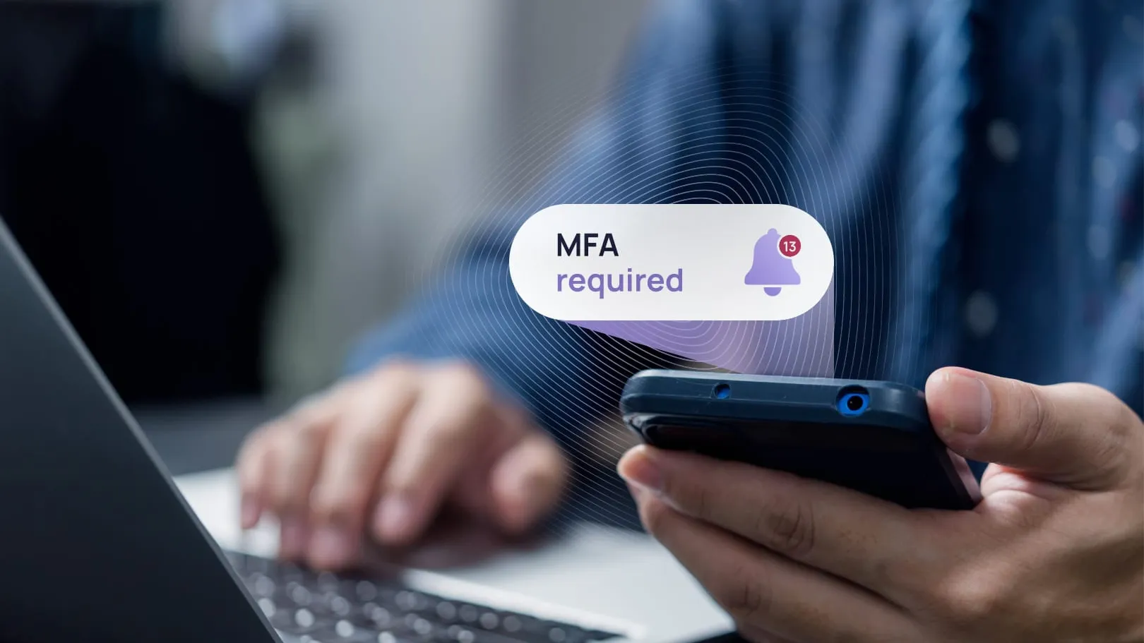 A hand holding a phone showing a multi-factor approval prompt