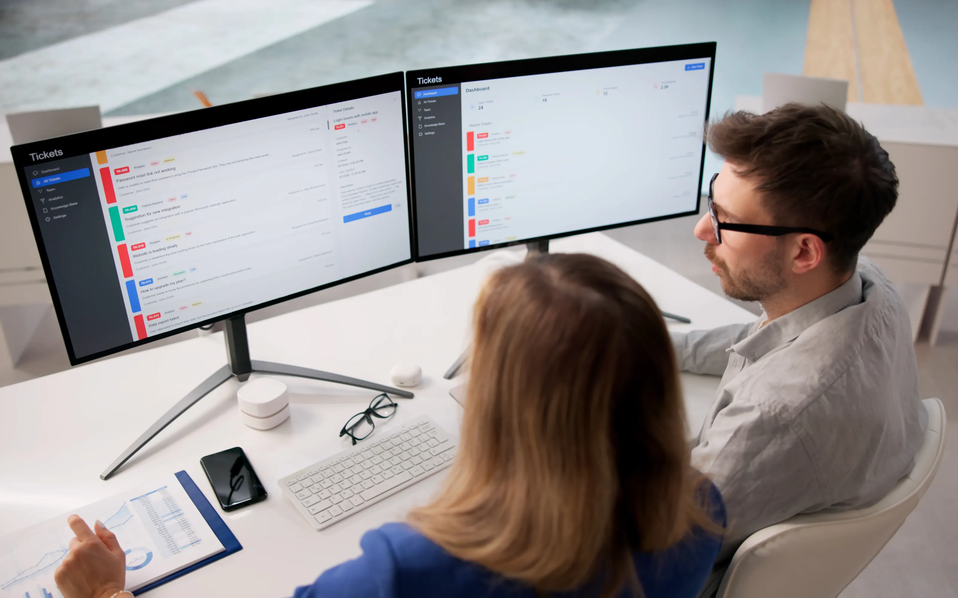 Two engineers working a live ticket queue on screen